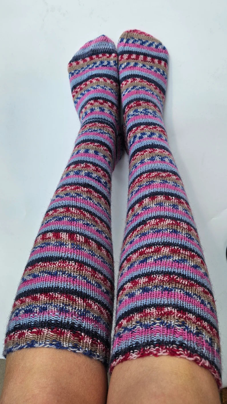 A pair of warm knee-high wool socks in vibrant colors, showcasing a cozy knit pattern, perfect for keeping feet comfortable during cold weather